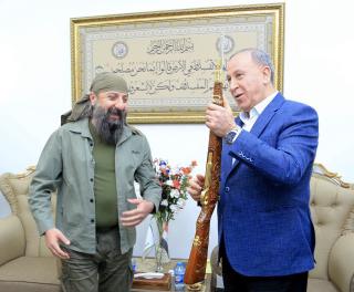 Osama al-Kaldani presents Khaled al-Obaidi with a Brno rifle