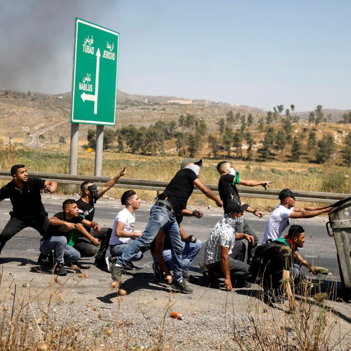 Palestinians throw stones near the West Bank border with Israel.