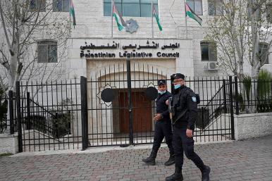 Police walk past the Palestinian Legislative Council in Ramallah
