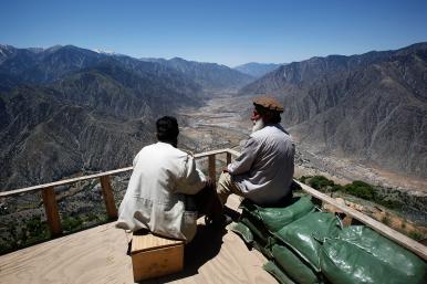 Afghan militia fighters survey a valley in Kunar province