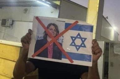 A Libyan protester holds up a sign denouncing Foreign Minister Najla al-Mangoush for meeting with an Israeli official.