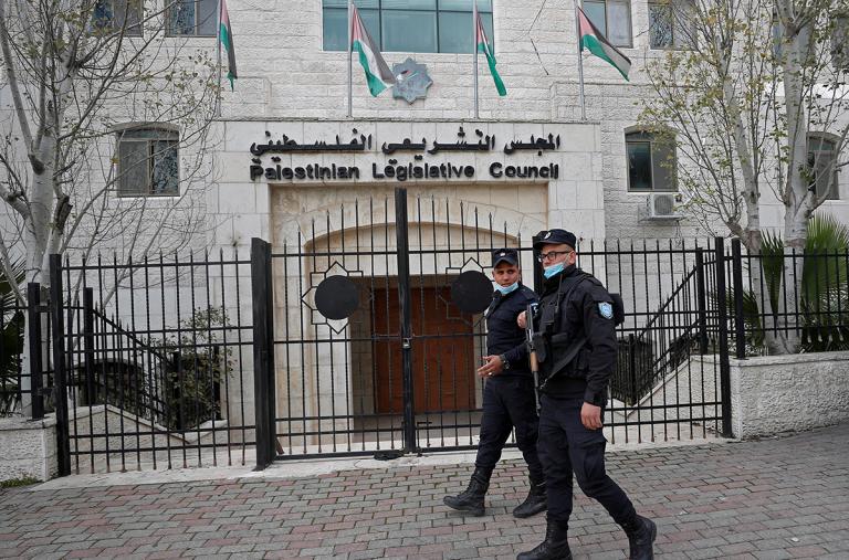 Police walk past the Palestinian Legislative Council in Ramallah