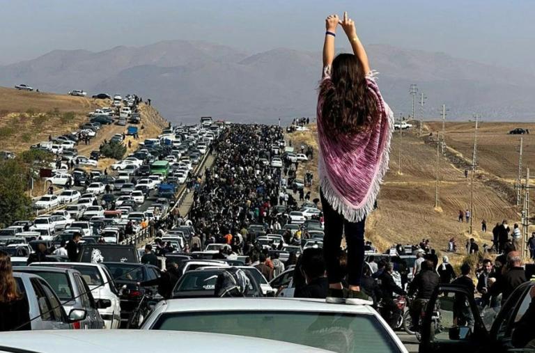 Twitter photo showing an Iranian woman standing on top of a car during a protest against the killing of Mahsa Amini.