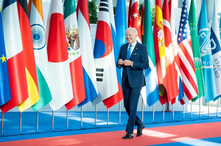 President Joe Biden walks past flags of the member states at a G20 meeting - source: The White House