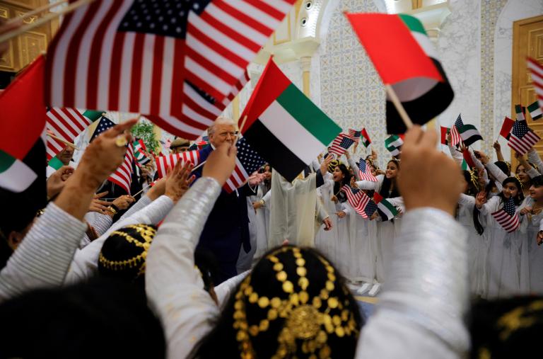 Children wave US and UAE flags during President Trump's May 2025 visit to Abu Dhabi - source: Reuters