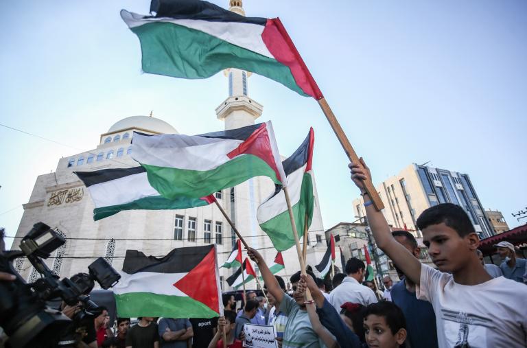 Protesters wave Palestinian flags in Gaza City - source: Reuters