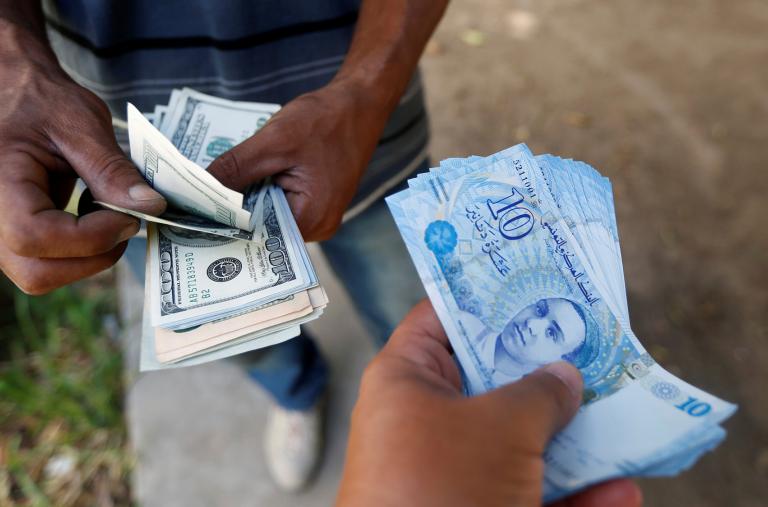 A Tunisian purchases dollars from a money-changer - source: Reuters