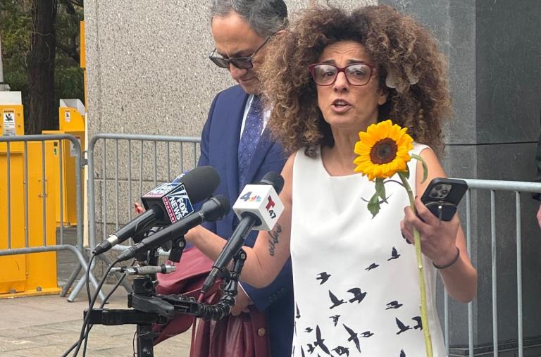 Iranian dissident Masih Alinejad speaks addresses a crowd at a courthouse - source: Holly Dagres