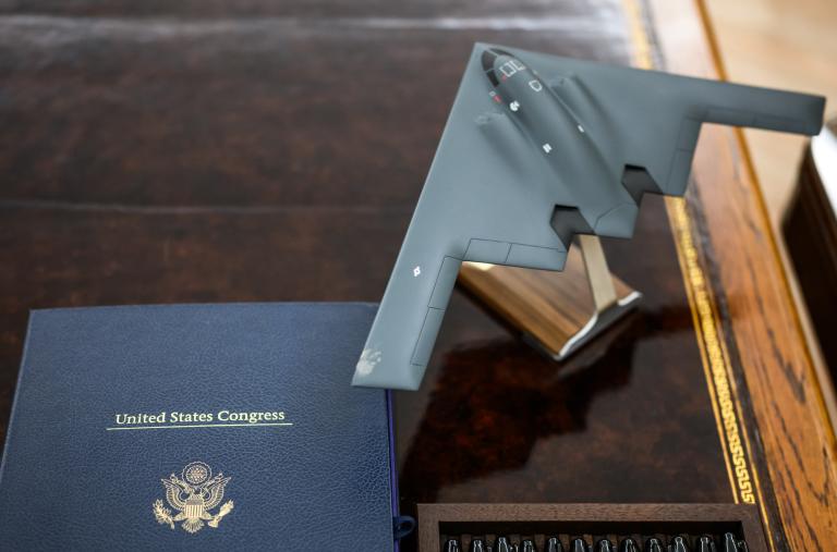 A model of a B-2 stealth bomber sits next to legislation on the president's Oval Office desk - source: The White House