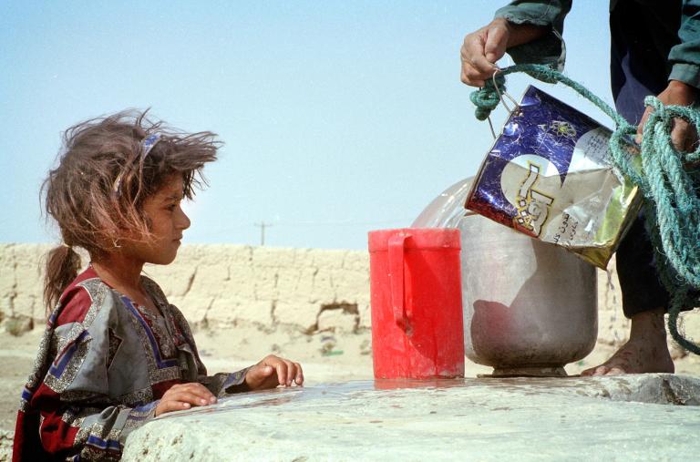 An Iranian girl watches water being poured - source: Reuters