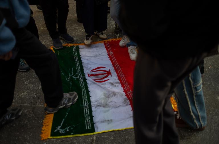 Protesters trample on an Iranian flag - source: Reuters