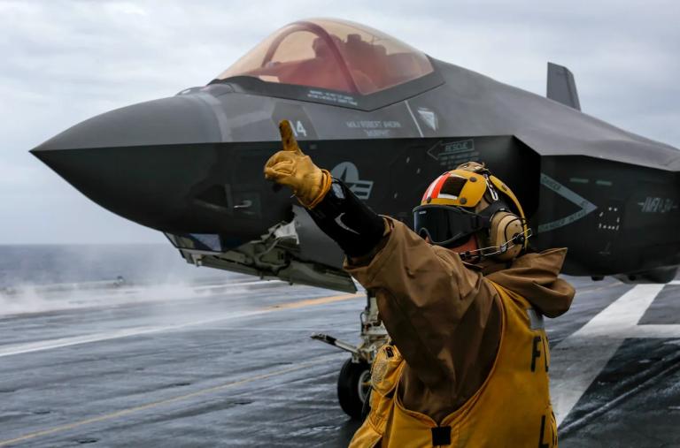 A flight deck crewman directs operations of an F-35 jet on board the USS Abraham Lincoln - source: Department of Defense