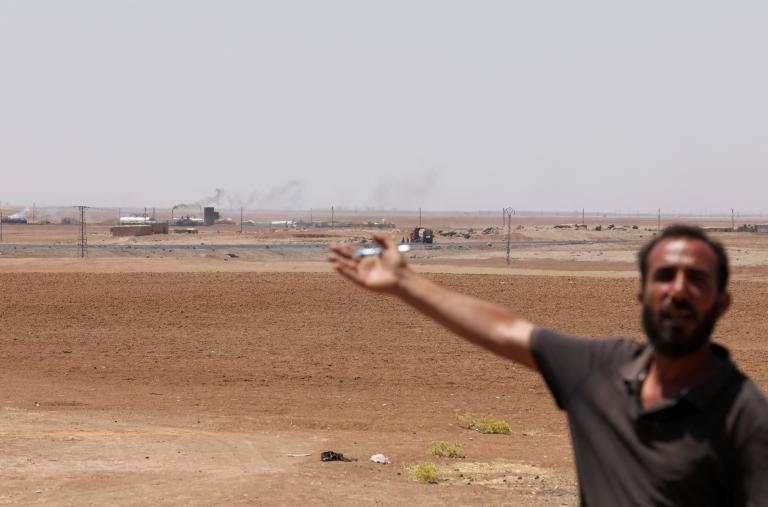 A Syrian man gestures at a makeshift oil refinery - source: Reuters