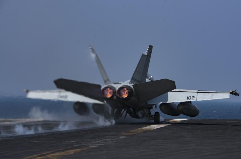 A US Navy F-18 lands on a carrier flight deck - source: Department of Defense