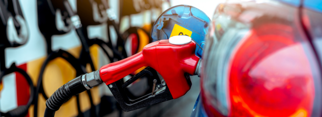 A gasoline pump nozzle filling an automobile.