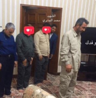 Abu Fadak prays in front of Qassem Soleimani.