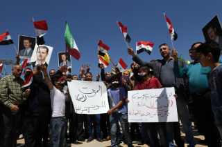 Aleppo Defenders Legion hold signs saying "Death to America and Israel".