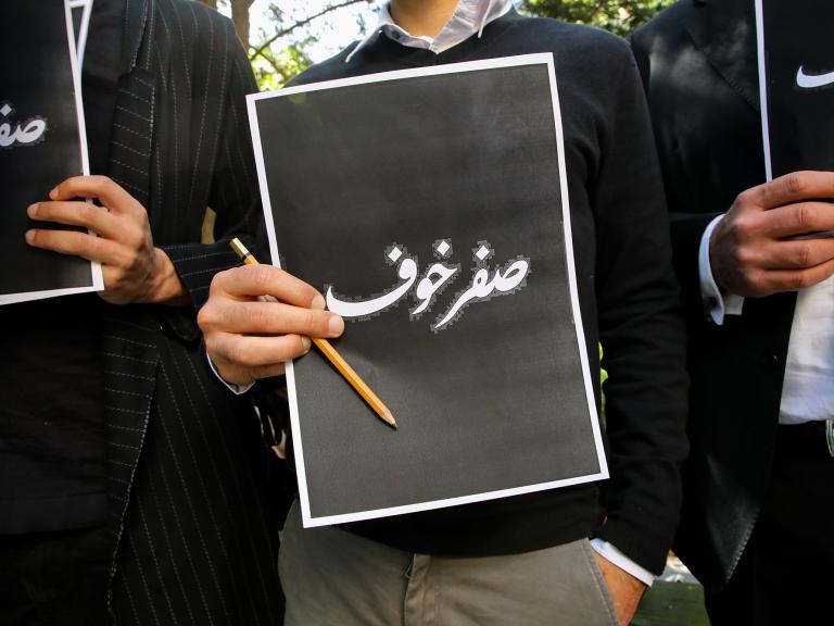 Lebanese protesters hold signs reading "Fearless" in Arabic in response to the assassination of Lokman Slim - source: Reuters