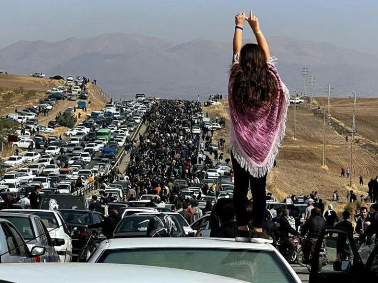 Twitter photo showing an Iranian woman standing on top of a car during a protest against the killing of Mahsa Amini.