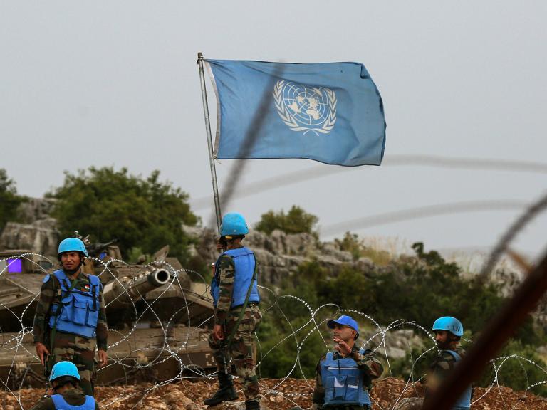 Photo showing an Israeli tank and UN peacekeeping forces on the border with Lebanon.