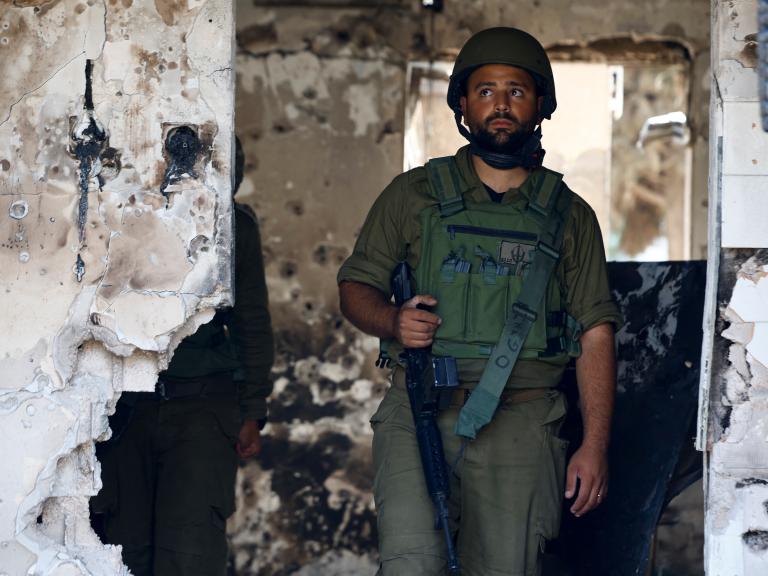 Photo of an Israeli soldier in the ruins of a kibbutz following the October 2023 Hamas attack.