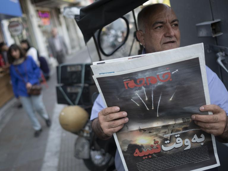 An Iranian man holds a newspaper depicting the April 14 attack on Israel.