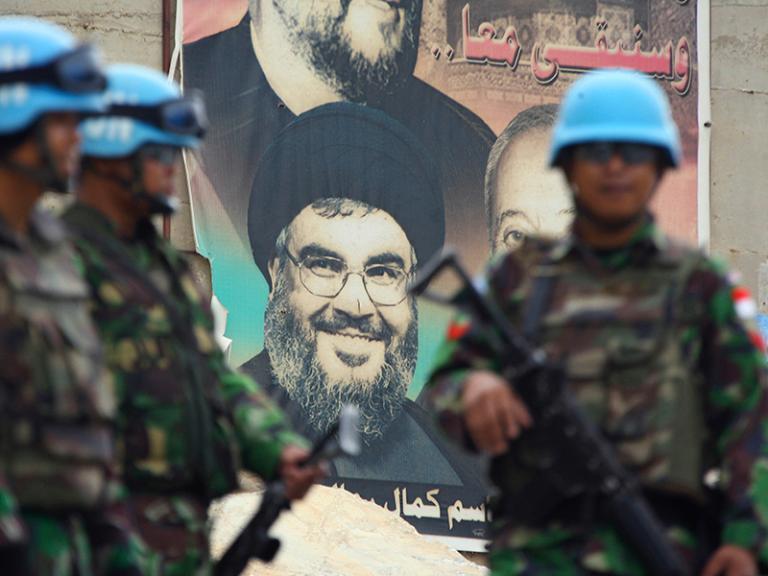 UNIFIL peacekeepers in Lebanon in front of a poster depicting Hezbollah chief Hassan Nasrallah - source: Reuters