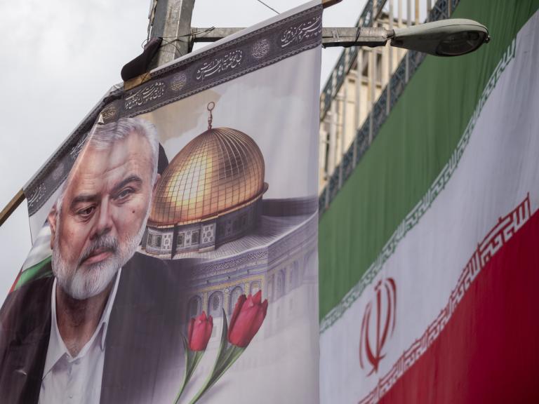 A poster depicts former Hamas leader Ismail Haniyeh alongside the Iranian flag in Tehran following Haniyeh's killing in Iran - source: Reuters