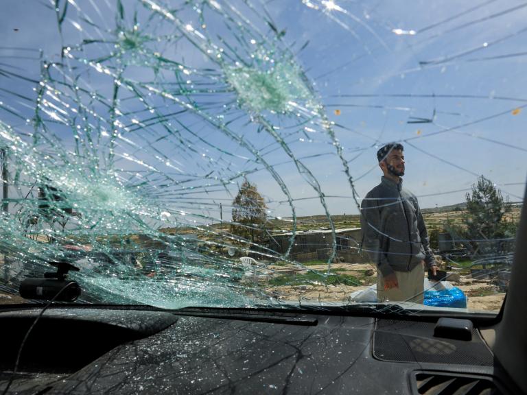 Oscar-winning Palestinian Director Basel Adra checks a damaged car after Israeli settlers' attack in Susiya in the Israeli-occupied West Bank - source: Reuters