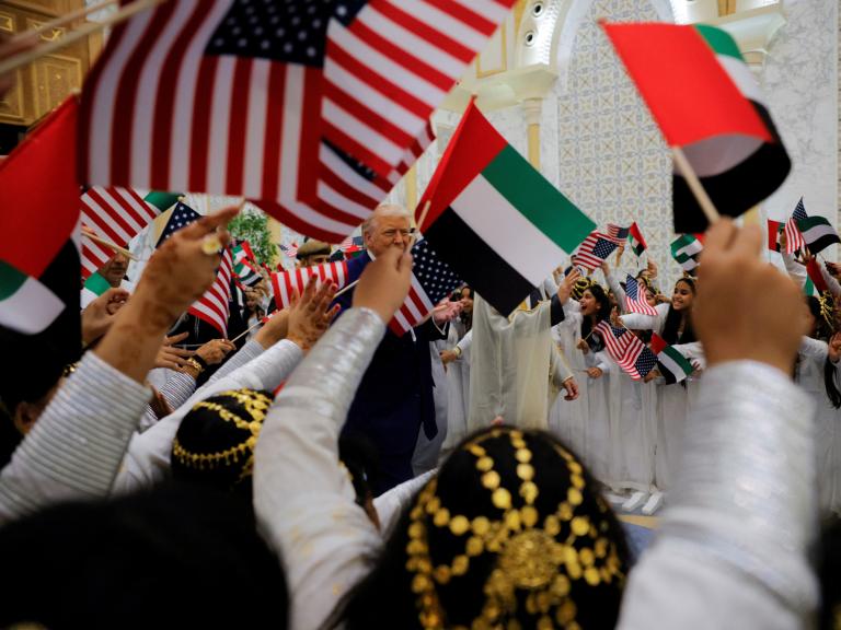 Children wave US and UAE flags during President Trump's May 2025 visit to Abu Dhabi - source: Reuters