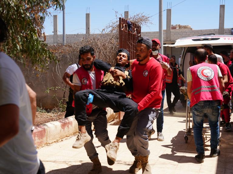 Photo of Syrian medics evacuating injured troops after violent clashes in Suwayda province..