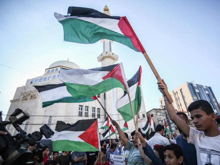 Protesters wave Palestinian flags in Gaza City - source: Reuters