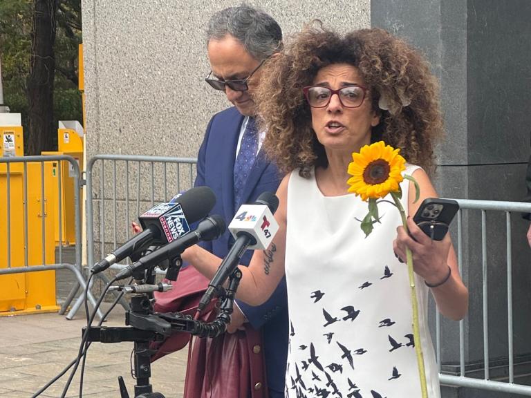Iranian dissident Masih Alinejad speaks addresses a crowd at a courthouse - source: Holly Dagres