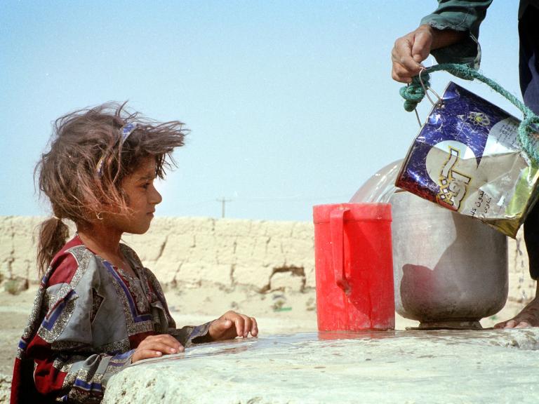 An Iranian girl watches water being poured - source: Reuters