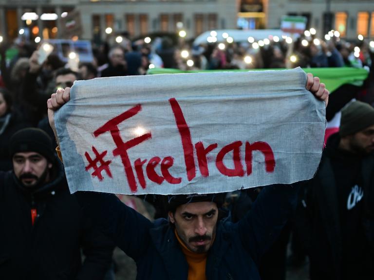 A protester holds a #FreeIran banner in Berlin - source: Reuters