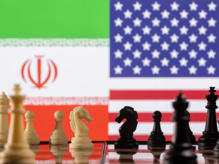 A photo illustration depicts chess pieces and the Iranian and U.S. flags - source: Reuters
