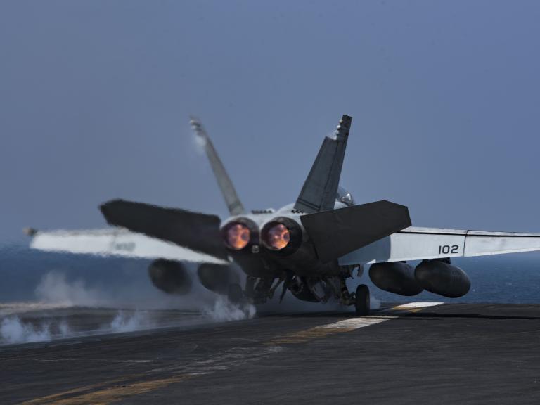 A US Navy F-18 lands on a carrier flight deck - source: Department of Defense