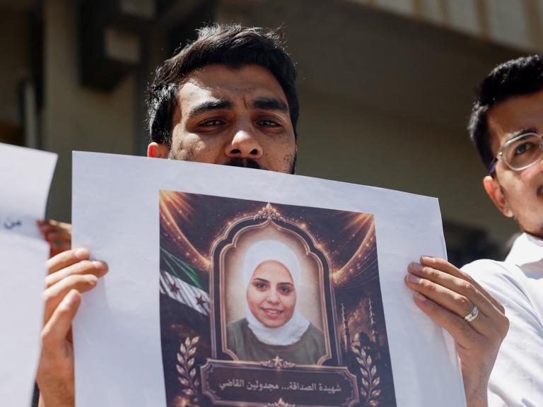 Photo of Syrians holding a memorial protest for family members killed by the former Assad regime.