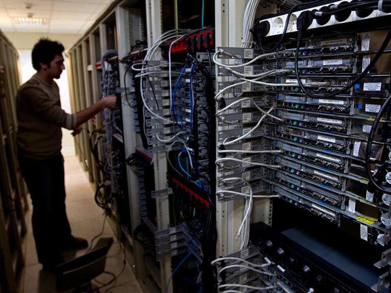 A man manipulates cables on a bank of internet data servers - source: Reuters