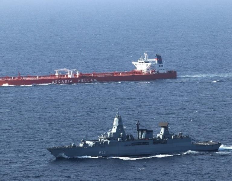 A commercial ship crosses the Bab al-Mandab Strait under the protection of a German navy frigate.