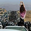 Twitter photo showing an Iranian woman standing on top of a car during a protest against the killing of Mahsa Amini.
