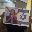 A Libyan protester holds up a sign denouncing Foreign Minister Najla al-Mangoush for meeting with an Israeli official.