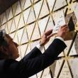 Secretary of State Antony Blinken places a tile that reads "Light in the darkness" on a wall at the Abrahamic Family House in Abu Dhabi, October 14, 2023.