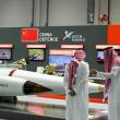 Men stand next to exhibits at the International Defence Exhibition in Abu Dhabi - source: Reuters