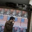 A man speaks on his phone in Beirut, Lebanon, in front of posters depicting the U.S. flag - source: Reuters