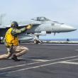 A sailor directs the launch of an F-18 from the flight deck of the carrier USS Harry S Truman - source: Department of Defense