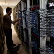 A man manipulates cables on a bank of internet data servers - source: Reuters