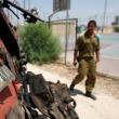 An Egyptian guard inspects bomb damage near the Gaza border in Sinai