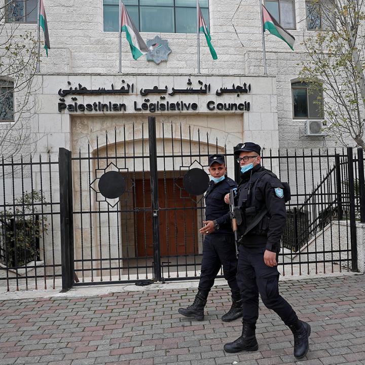 Police walk past the Palestinian Legislative Council in Ramallah