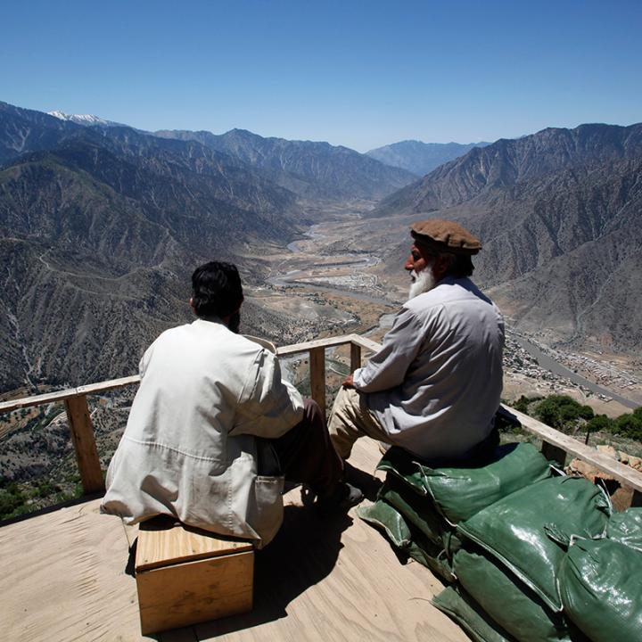 Afghan militia fighters survey a valley in Kunar province